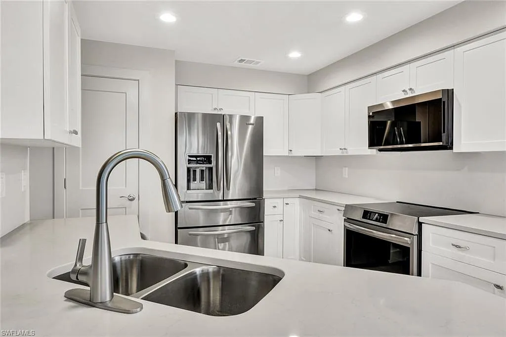 Kitchen detail with white cabinetry and a stainless steel sink