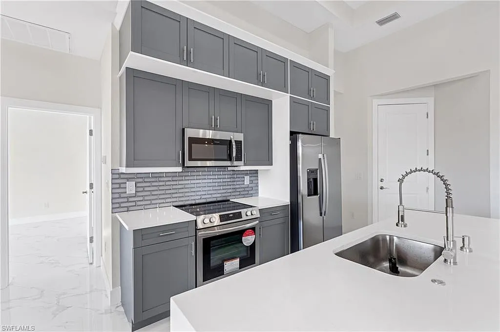 Dark kitchen cabinetry with a stainless steel range and refrigerator